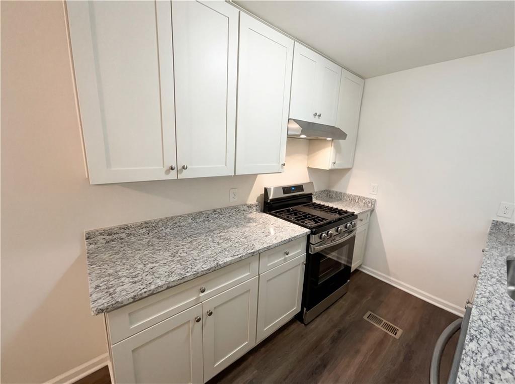 161 Grove Road Locust Grove, GA 30248 - Photo 9 of 18 a kitchen with granite countertop cabinets stainless steel appliances and a wooden floor