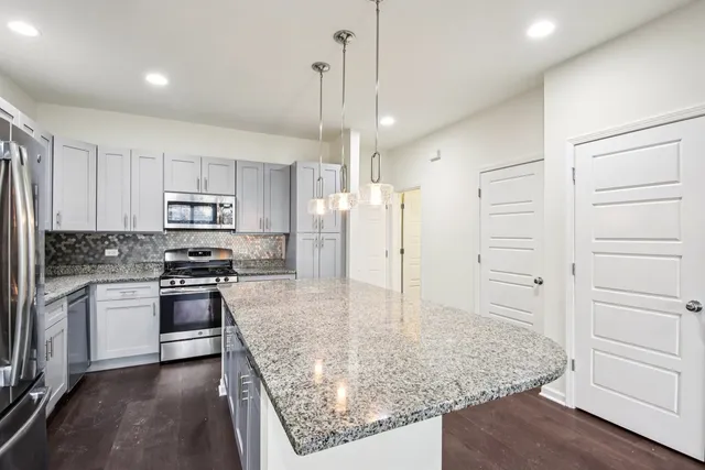 a kitchen with stainless steel appliances granite countertop a stove and a refrigerator