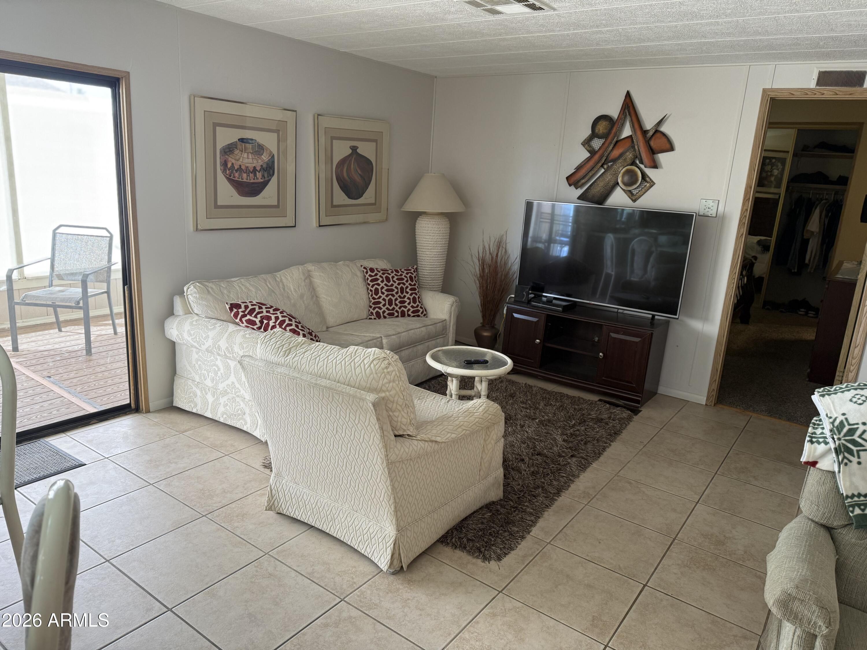 301 South Signal Butte Road, Unit 706 Apache Junction, AZ 85120 - Photo 19 of 51 a living room with furniture and a flat screen tv