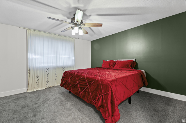 822 Pinewood Circle Price, UT 84501 - Photo 12 of 49 Large bedroom featuring a full wall of deep green accent paint, and a multi-speed ceiling fan with integrated lighting