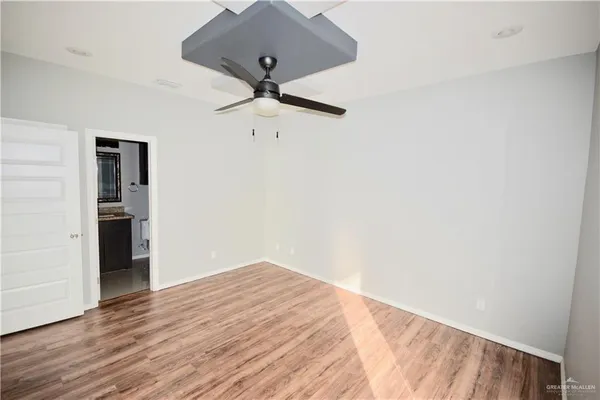 an empty room with wooden floor closet and ceiling fan