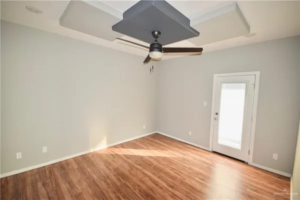 a view of a room with wooden floor and a ceiling fan