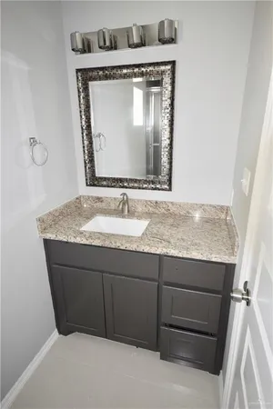 a bathroom with a granite countertop sink a mirror and vanity