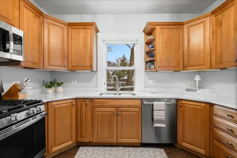 a kitchen with stainless steel appliances granite countertop a sink a stove and a microwave