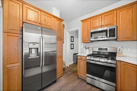 a kitchen with granite countertop wooden cabinets stainless steel appliances and a window