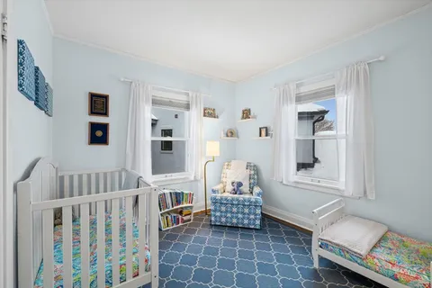 a living room with furniture and baby crib