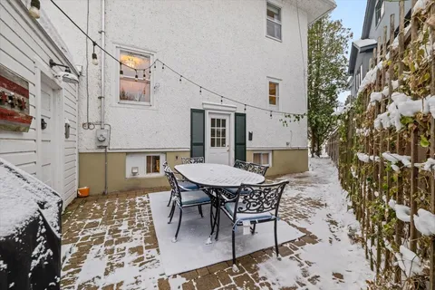a patio with table and chairs and potted plants