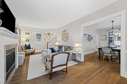 a living room with furniture a fireplace and wooden floor