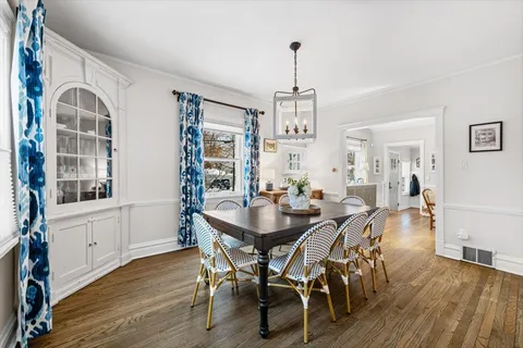 a view of a a dining room with furniture window and wooden floor