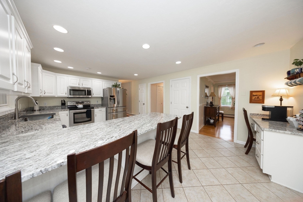 49 Dennis Whitney Road Oakham, MA 01068 - Photo 7 of 40 a kitchen with stainless steel appliances granite countertop a stove top oven a sink a refrigerator and chairs