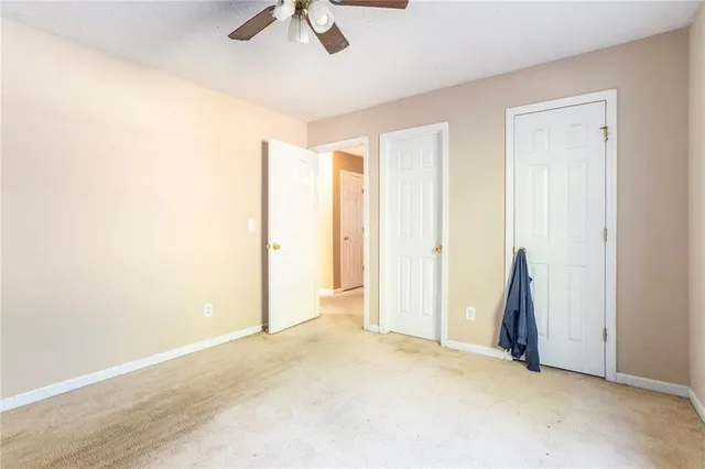 an empty room with ceiling fan and window