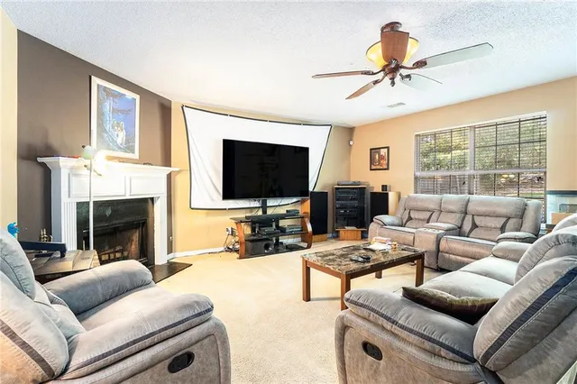 a living room with furniture a fireplace and a flat screen tv