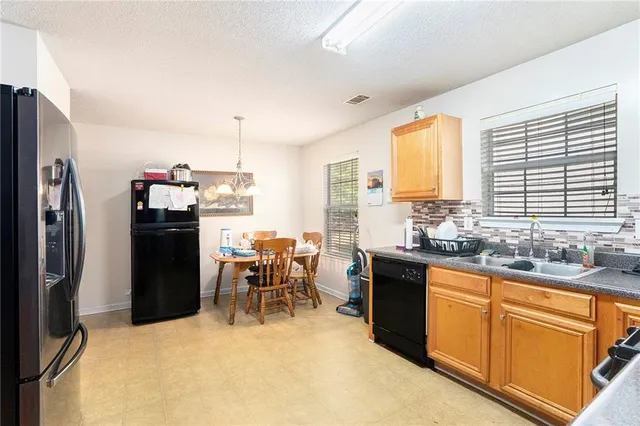a kitchen with granite countertop a sink stove and refrigerator