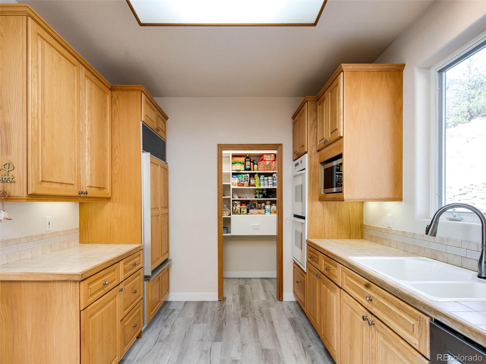180 Nuthatch Road Evergreen, CO 80439 - Photo 12 of 40 a kitchen with stainless steel appliances granite countertop a sink and wooden cabinets