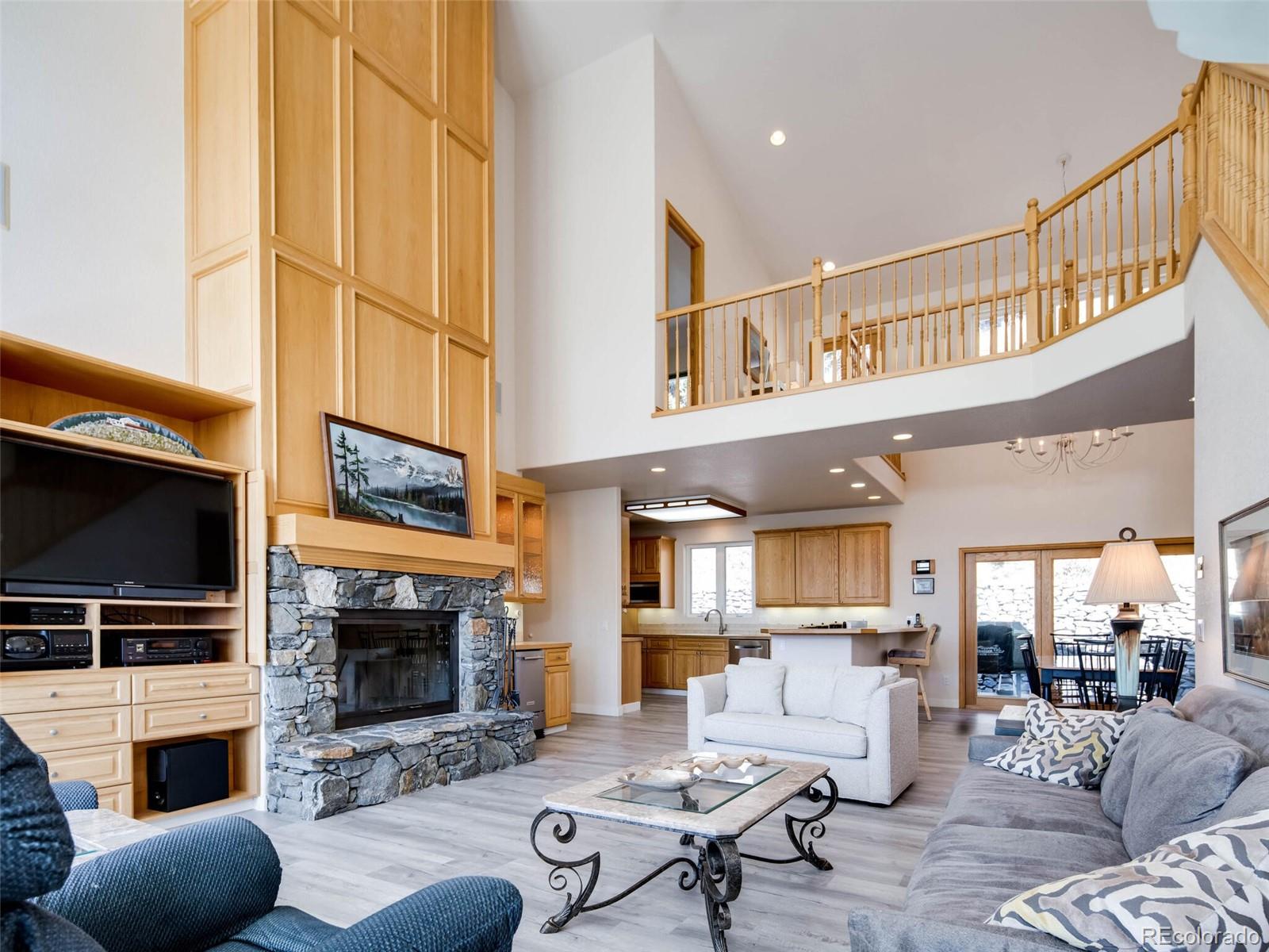 180 Nuthatch Road Evergreen, CO 80439 - Photo 2 of 40 a living room with furniture a flat screen tv and a fireplace