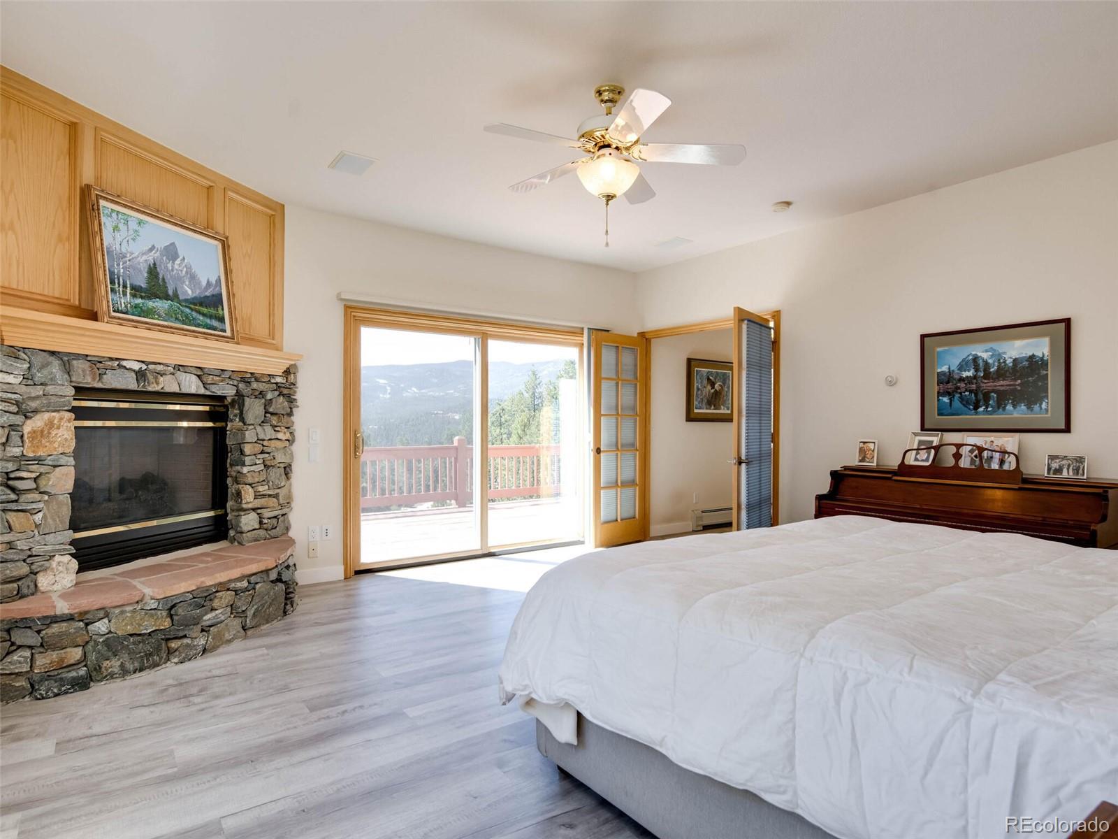 180 Nuthatch Road Evergreen, CO 80439 - Photo 22 of 40 a bedroom with a large bed and a fireplace