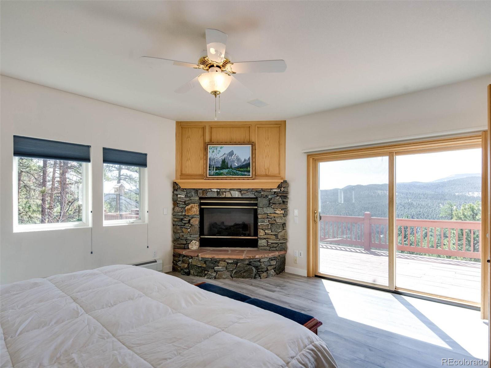 180 Nuthatch Road Evergreen, CO 80439 - Photo 23 of 40 a bedroom with furniture fireplace and a flat screen tv