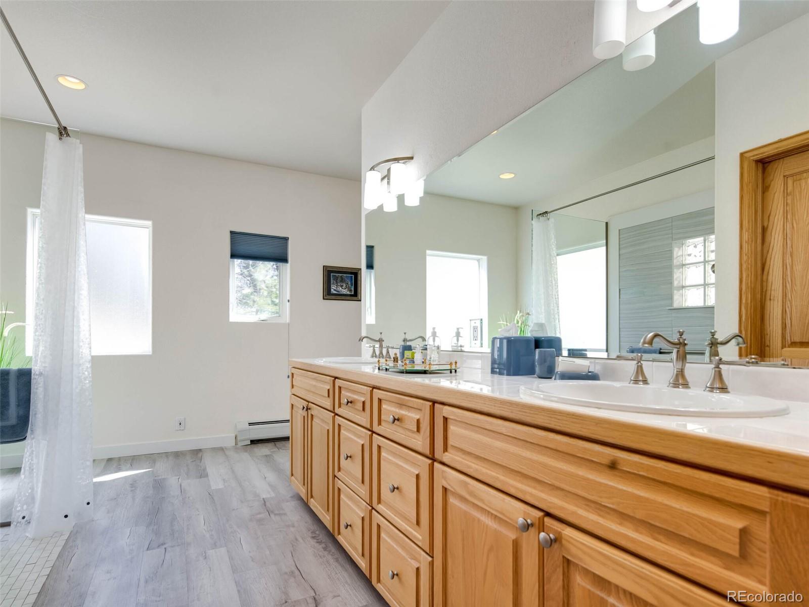 180 Nuthatch Road Evergreen, CO 80439 - Photo 24 of 40 a spacious bathroom with double vanity a mirror and a bathtub