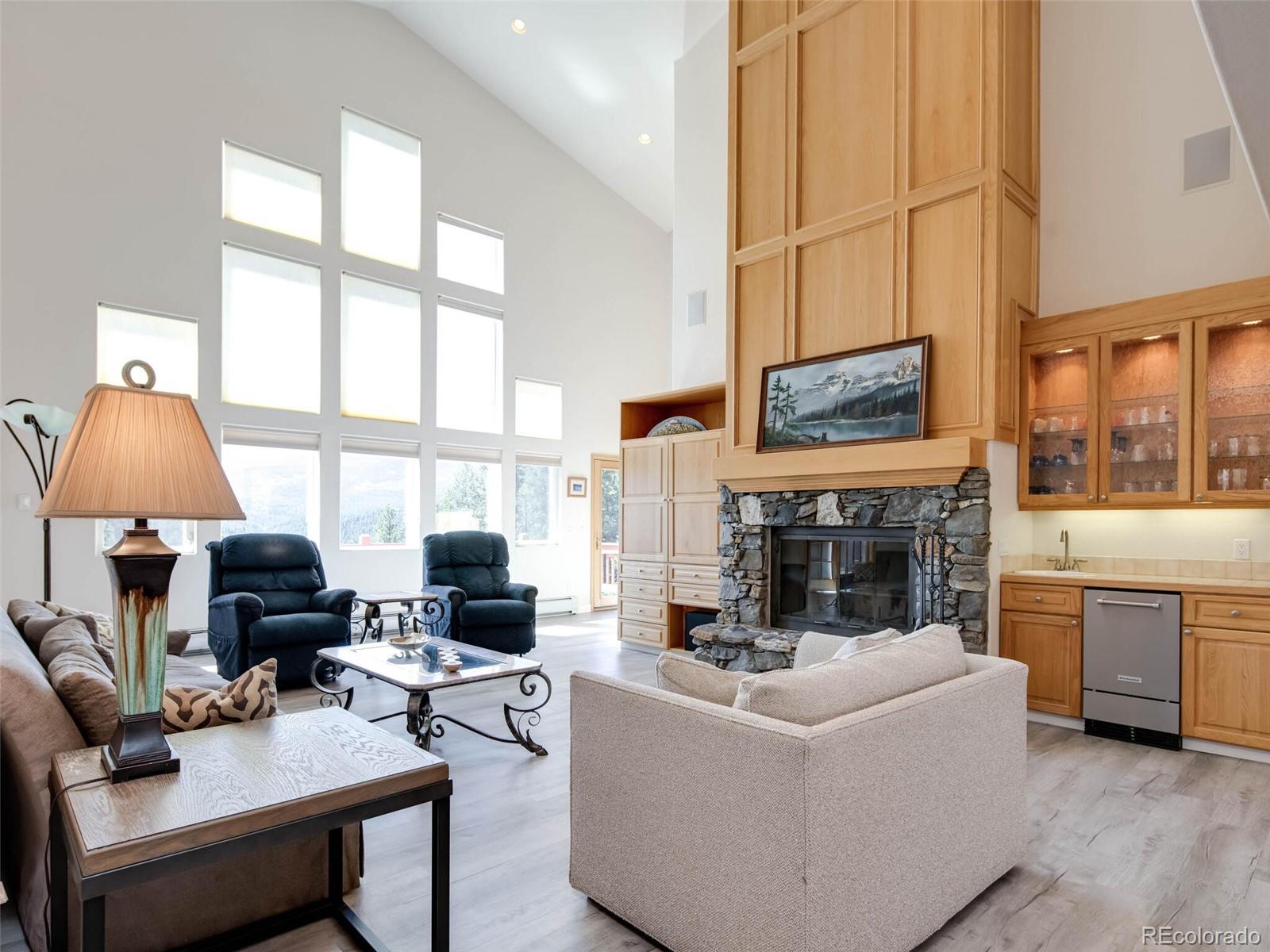 180 Nuthatch Road Evergreen, CO 80439 - Photo 3 of 40 a living room with furniture a fireplace and a flat screen tv