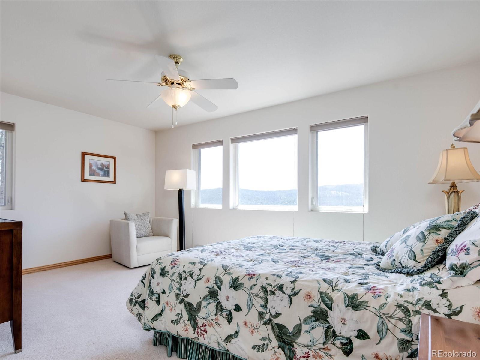 180 Nuthatch Road Evergreen, CO 80439 - Photo 34 of 40 a bedroom with a bed and a chandelier