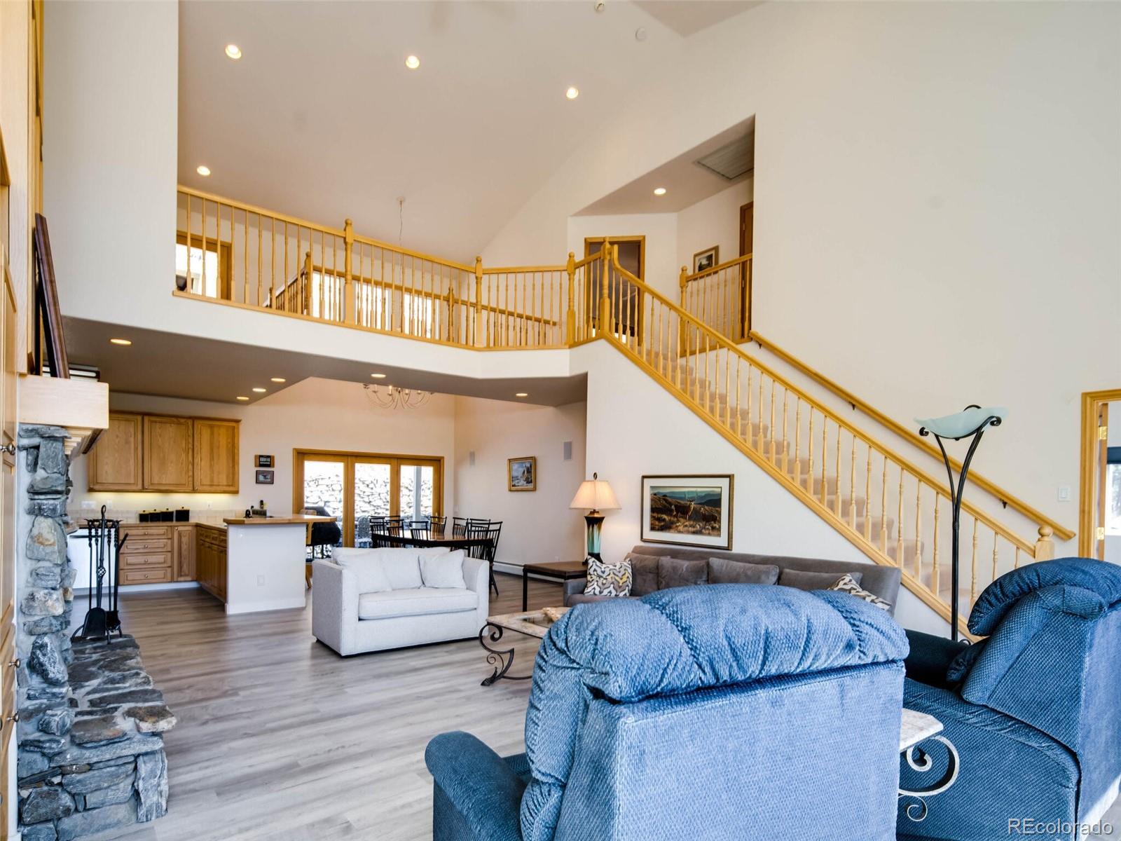 180 Nuthatch Road Evergreen, CO 80439 - Photo 4 of 40 a living room with couches and kitchen view with wooden floor
