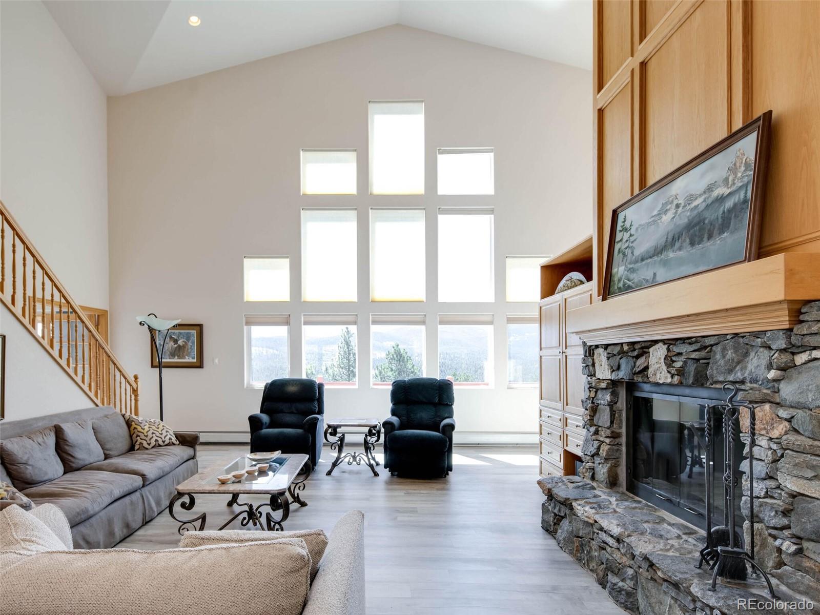180 Nuthatch Road Evergreen, CO 80439 - Photo 5 of 40 a living room with furniture a fireplace and a floor to ceiling window