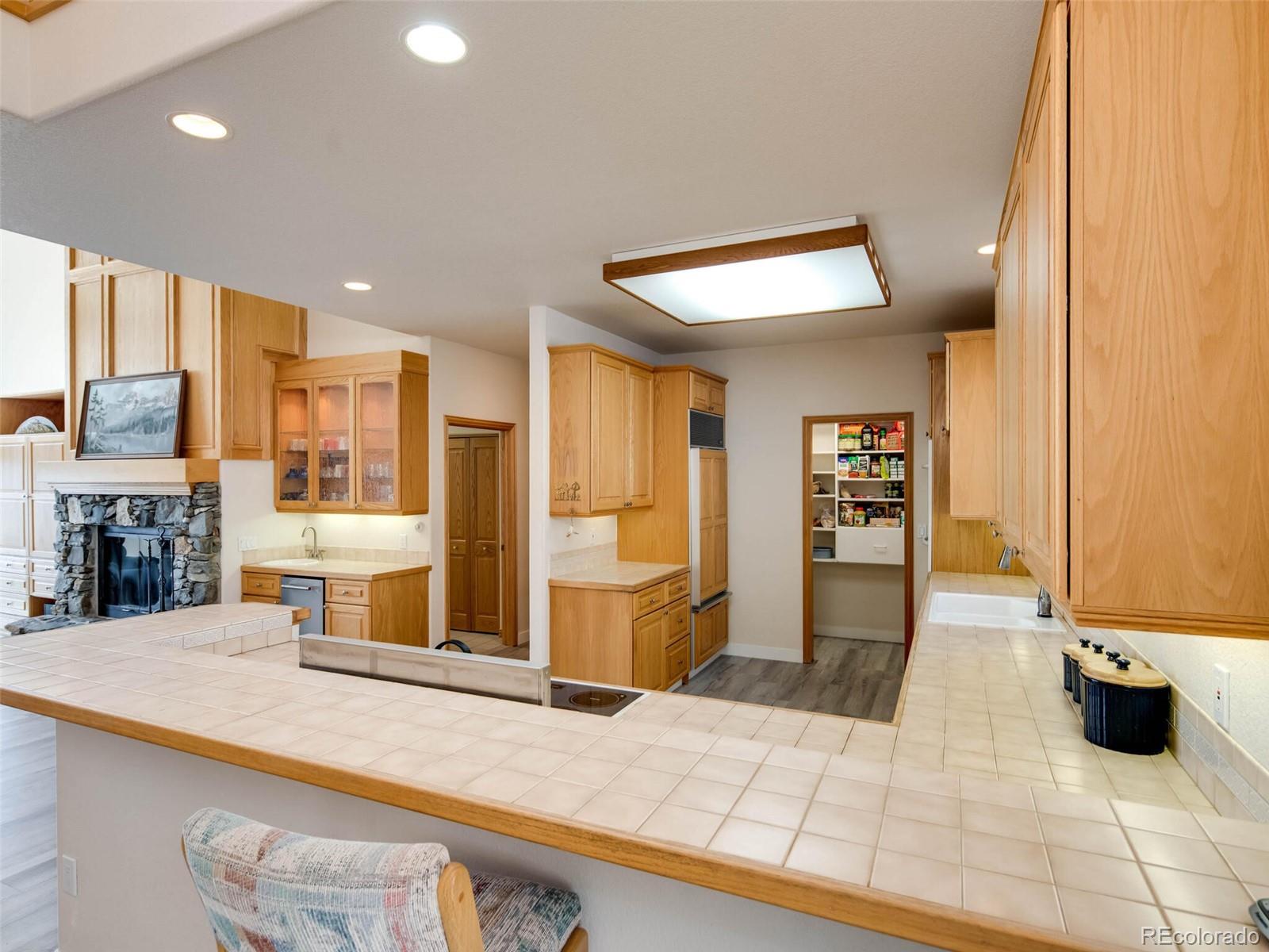 180 Nuthatch Road Evergreen, CO 80439 - Photo 8 of 40 a kitchen with stainless steel appliances kitchen island granite countertop a refrigerator and cabinets