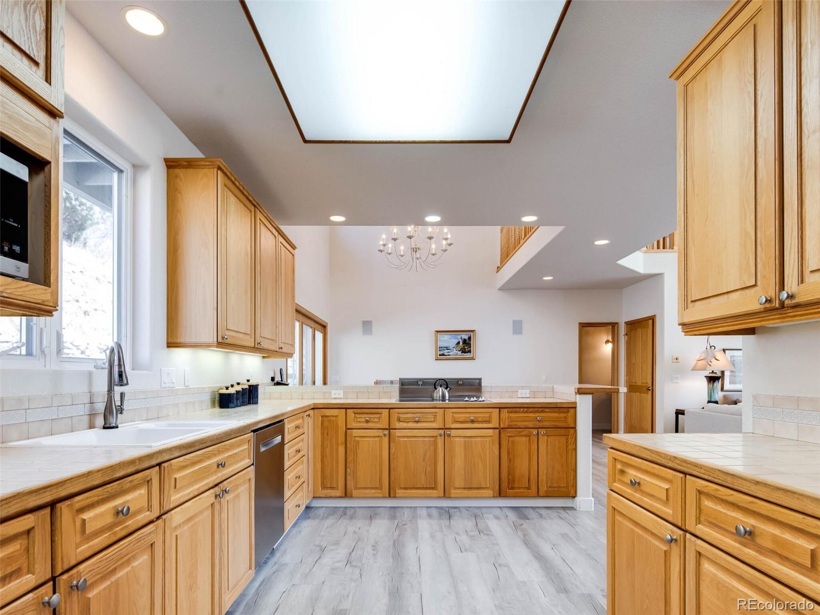 180 Nuthatch Road Evergreen, CO 80439 - Photo 9 of 40 a large kitchen with a large window a sink dishwasher and white appliances