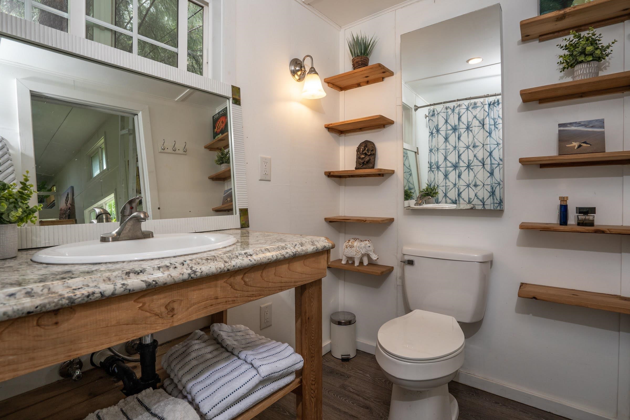 1740 Kokomo Road, Unit B Haiku, HI 96708 - Photo 13 of 29 a bathroom with a granite countertop toilet sink and mirror