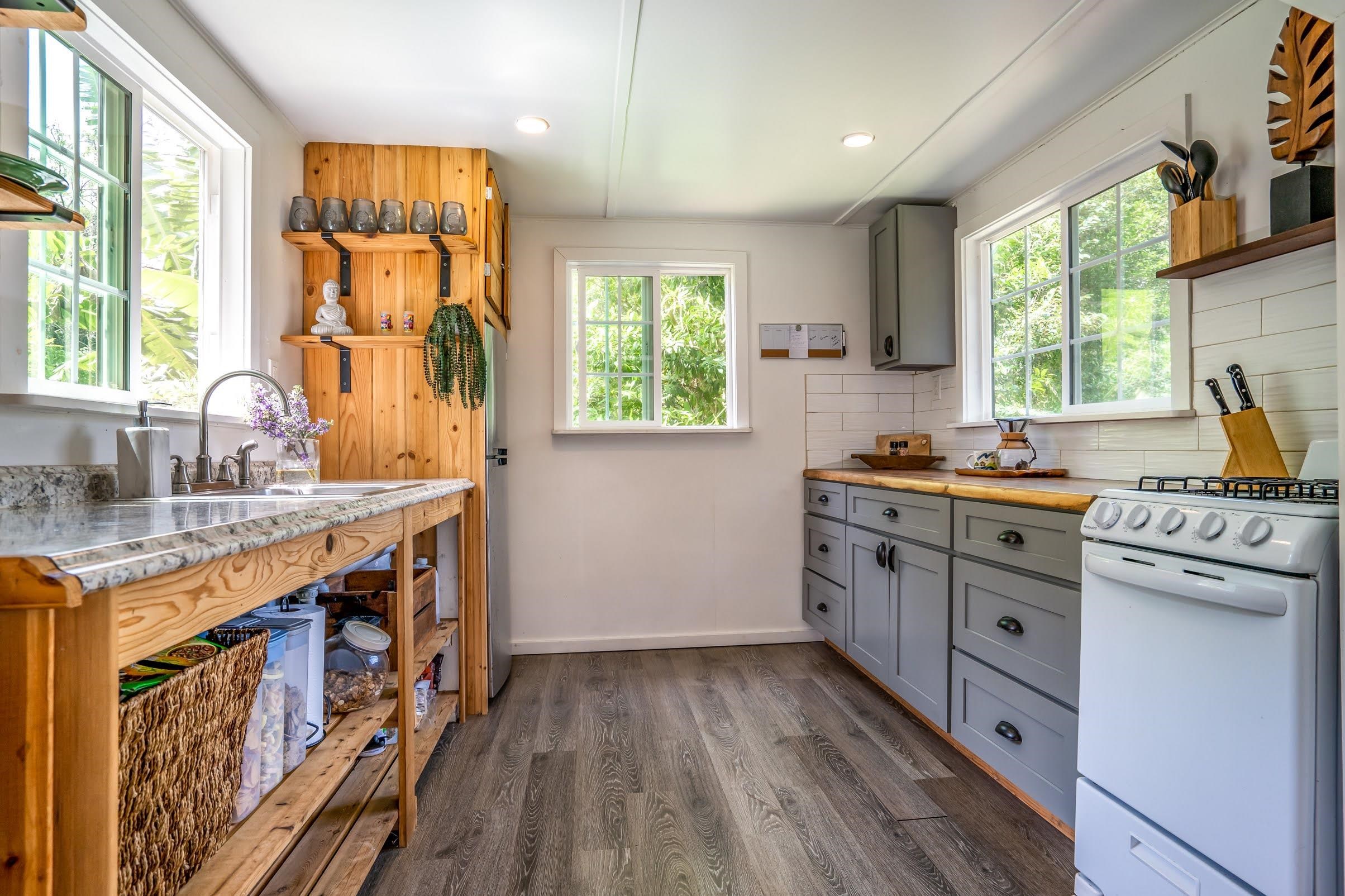 1740 Kokomo Road, Unit B Haiku, HI 96708 - Photo 14 of 29 a kitchen with cabinets wooden floor and a window