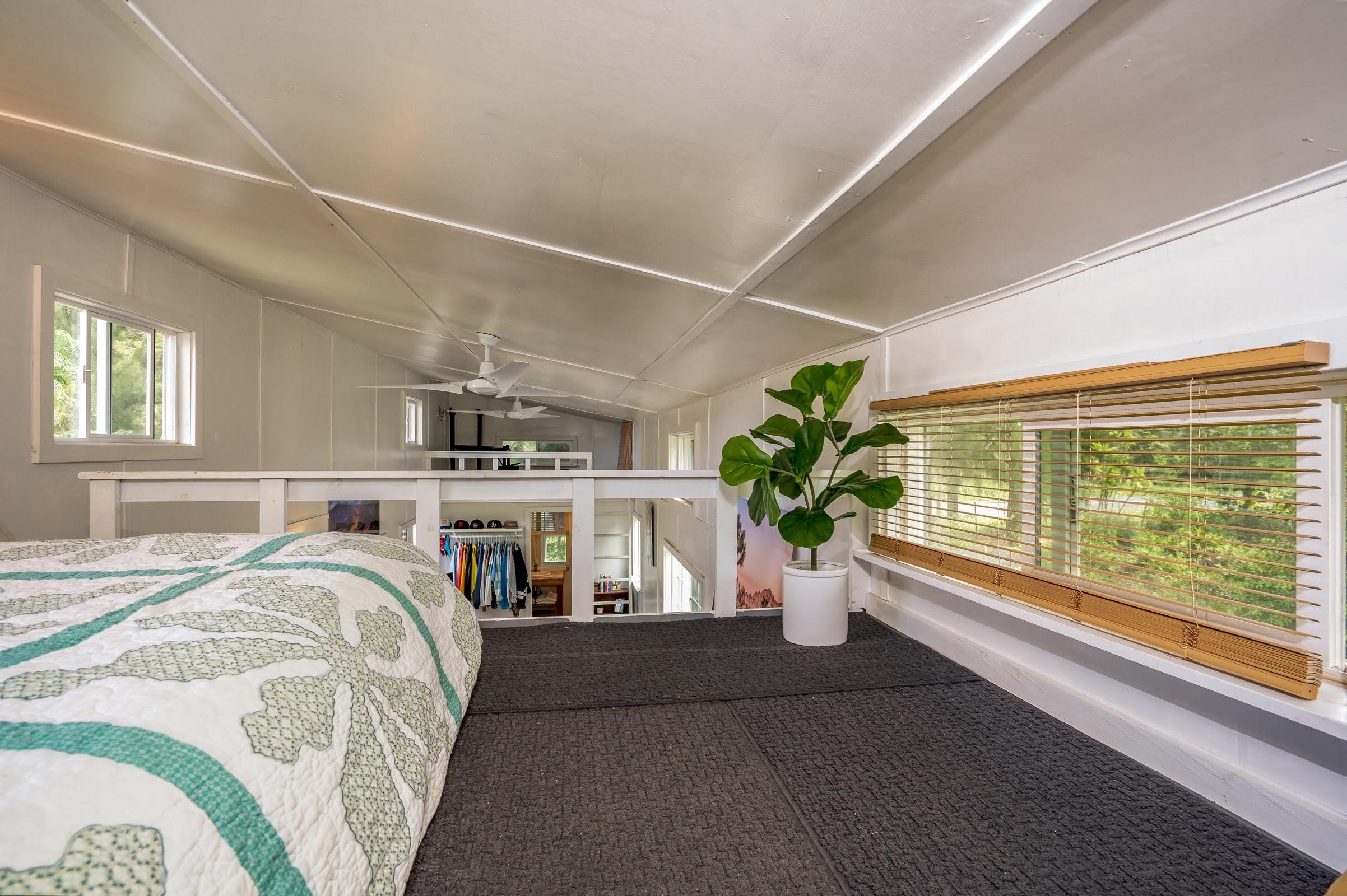 1740 Kokomo Road, Unit B Haiku, HI 96708 - Photo 24 of 29 a living room with a bed furniture and a potted plant