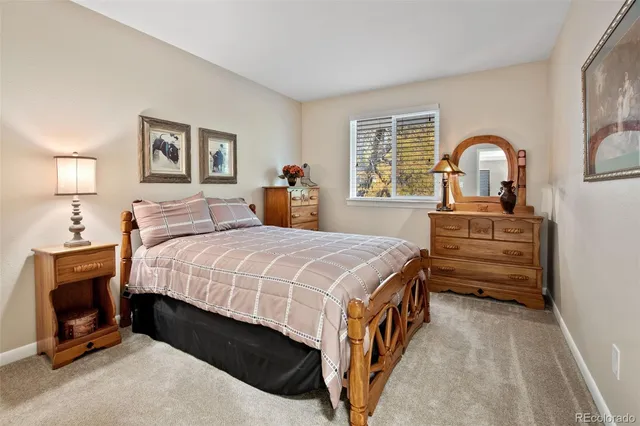a bedroom with a bed and a dresser next to a window