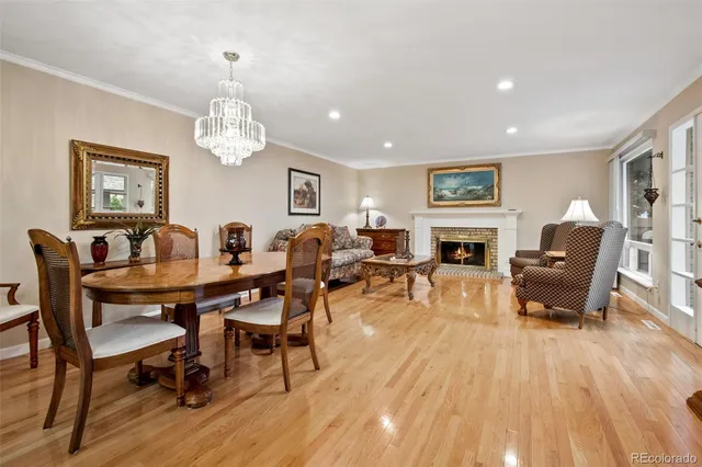 a view of a dining room with furniture a chandelier and wooden floor