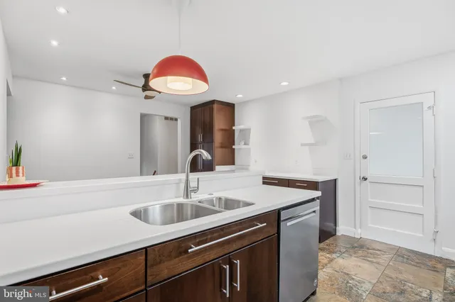 a kitchen with stainless steel appliances granite countertop a sink and a refrigerator