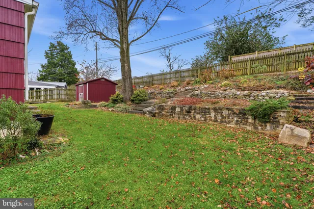 a view of a yard with wooden fence