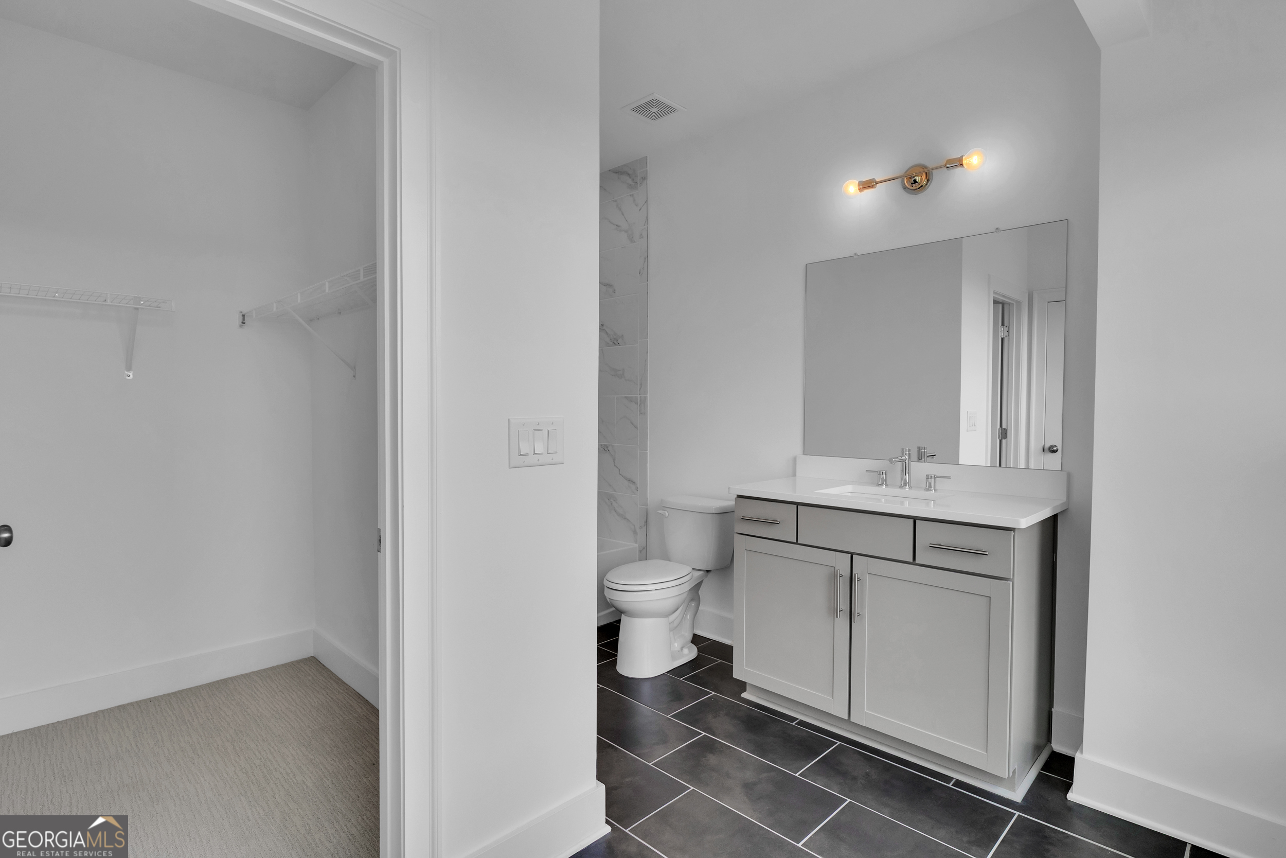 545 Whitlox Road Northwest Atlanta, GA 30309 - Photo 16 of 65 a bathroom with a toilet sink and mirror