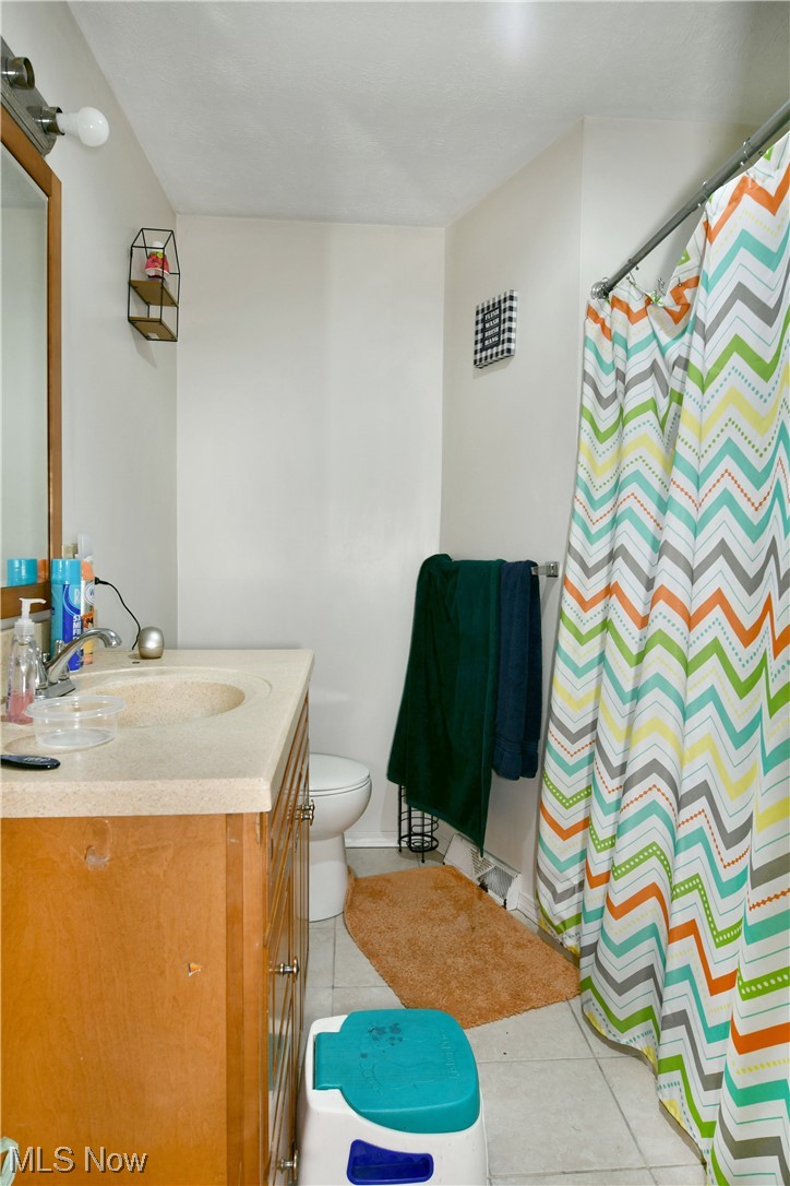 1357 Deforest Road Southeast Warren, OH 44484 - Photo 17 of 34 Bathroom with tile floors, toilet, and vanity