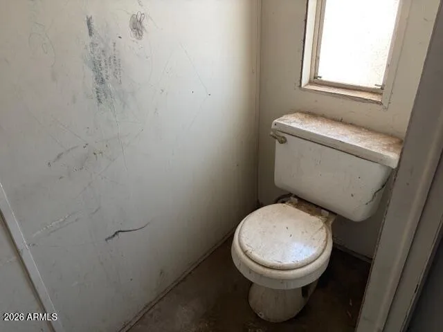 a white toilet sitting next to a window