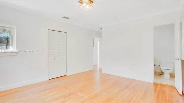 a view of empty room with wooden floor
