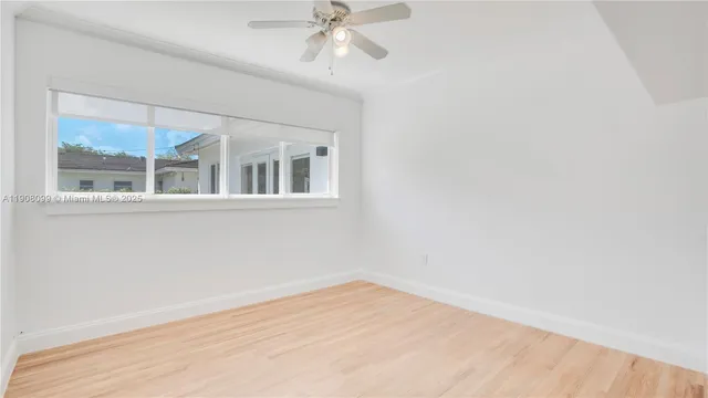 a view of a big room with wooden floor and windows