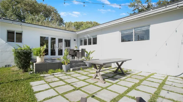 a view of a patio with table and chairs with wooden floor and plants