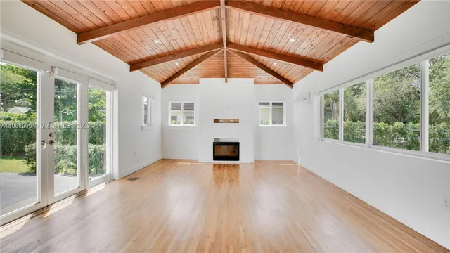 a view of a livingroom with wooden floor a ceiling fan and window