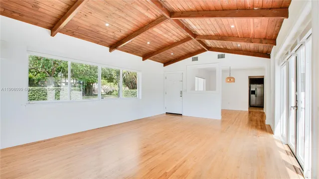 a view of empty room with wooden floor and windows