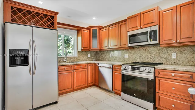 a kitchen with stainless steel appliances granite countertop a refrigerator stove and microwave