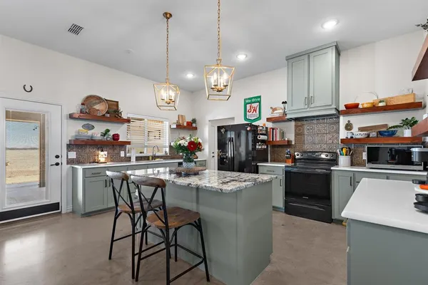 a kitchen with stainless steel appliances granite countertop a sink a stove and a refrigerator