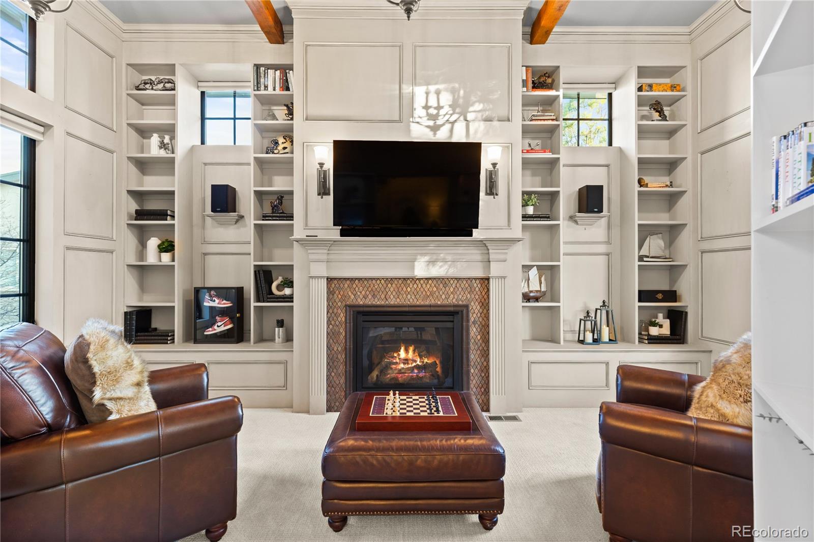 1033 Buffalo Ridge Road Castle Pines, CO 80108 - Photo 23 of 43 a living room with furniture a flat screen tv and a fireplace