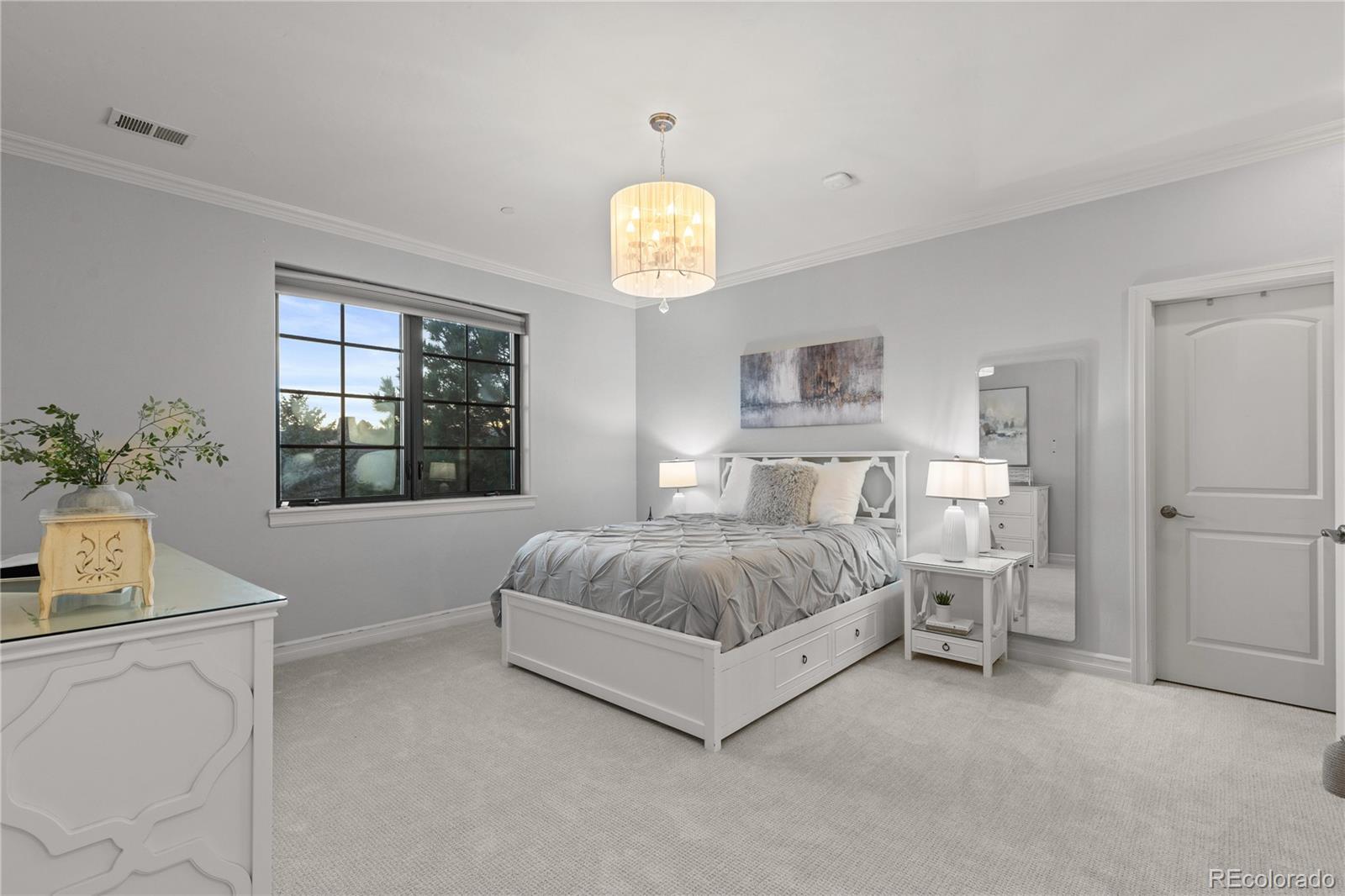 1033 Buffalo Ridge Road Castle Pines, CO 80108 - Photo 26 of 43 a spacious bedroom with a bed and a window