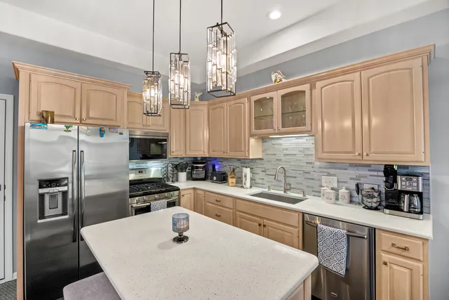 a kitchen with stainless steel appliances a sink stove refrigerator and cabinets