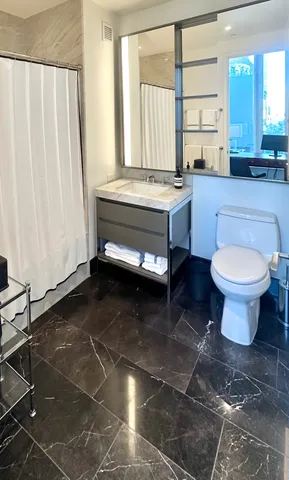 a bathroom with a sink toilet and window