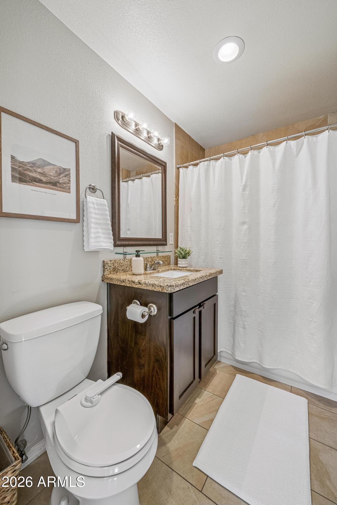 2327 East Weldon Avenue Phoenix, AZ 85016 - Photo 15 of 34 a bathroom with a toilet a sink and a mirror